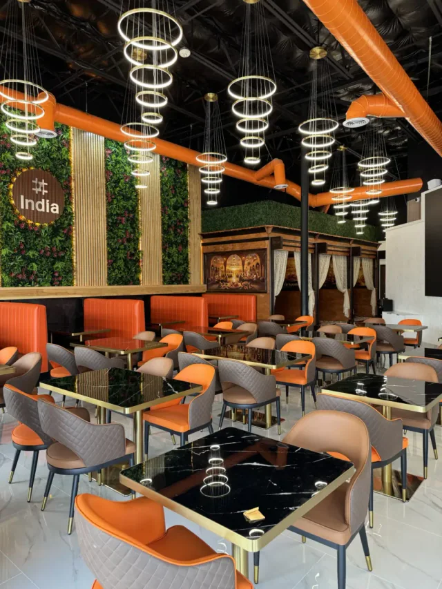 Hashtag India dining room with orange seating and illuminated ring lights